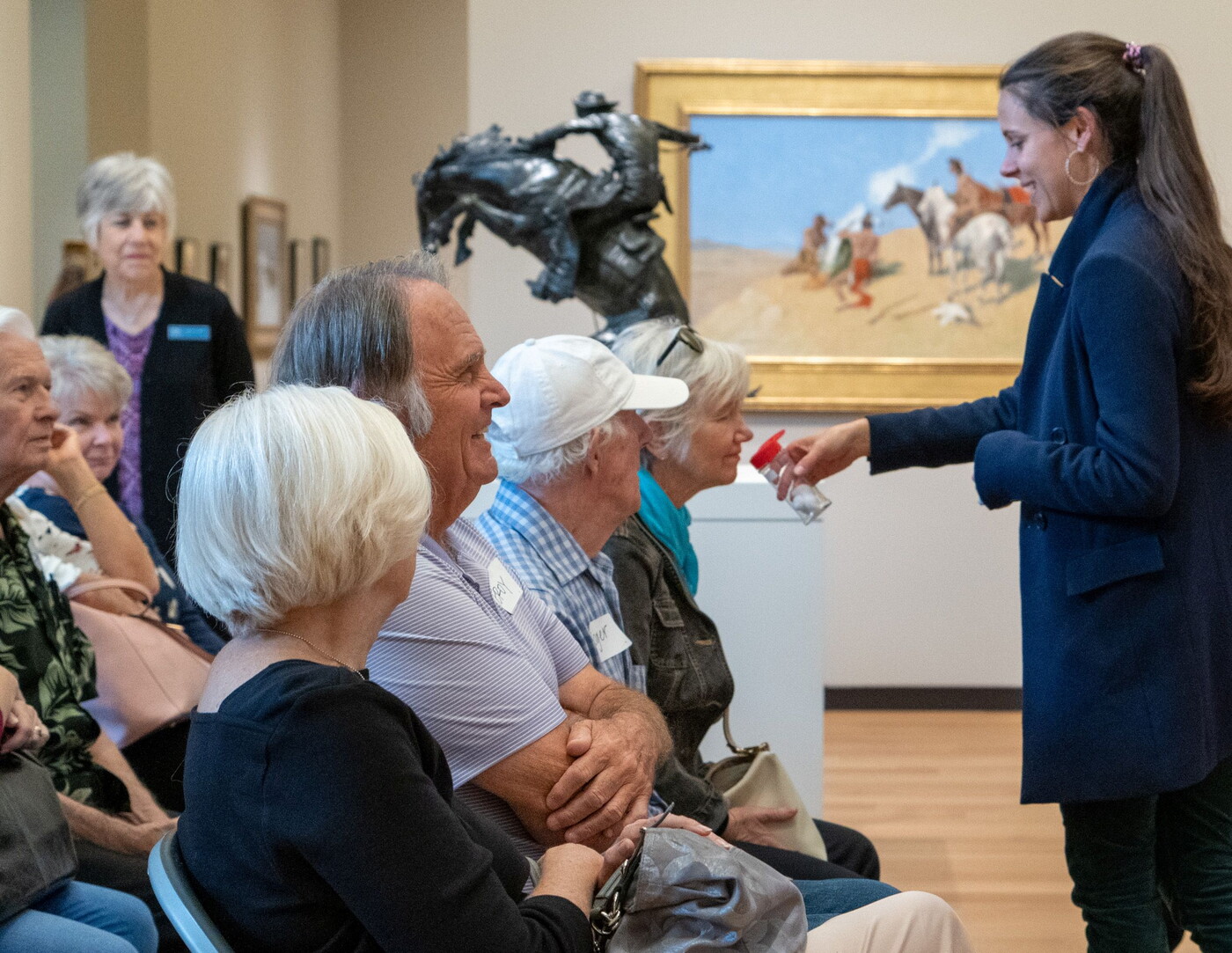 A group smells something held by a staff member in the Carter galleries