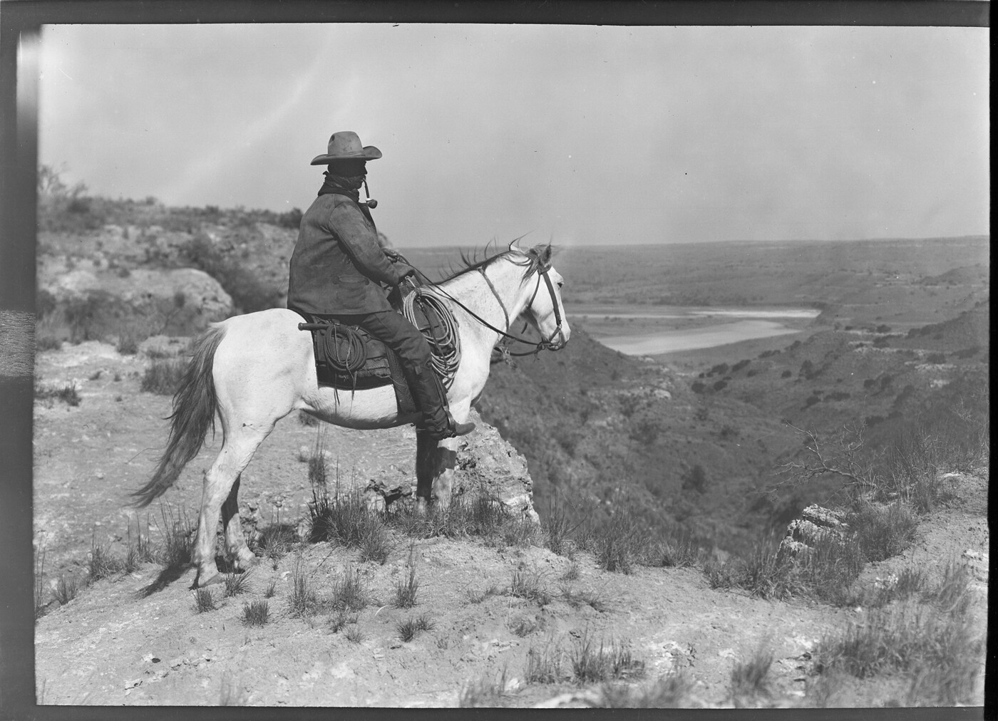 Billy Partlow, the "Pitchfork Kid," mounted on his white horse, overlooking the country. Matador