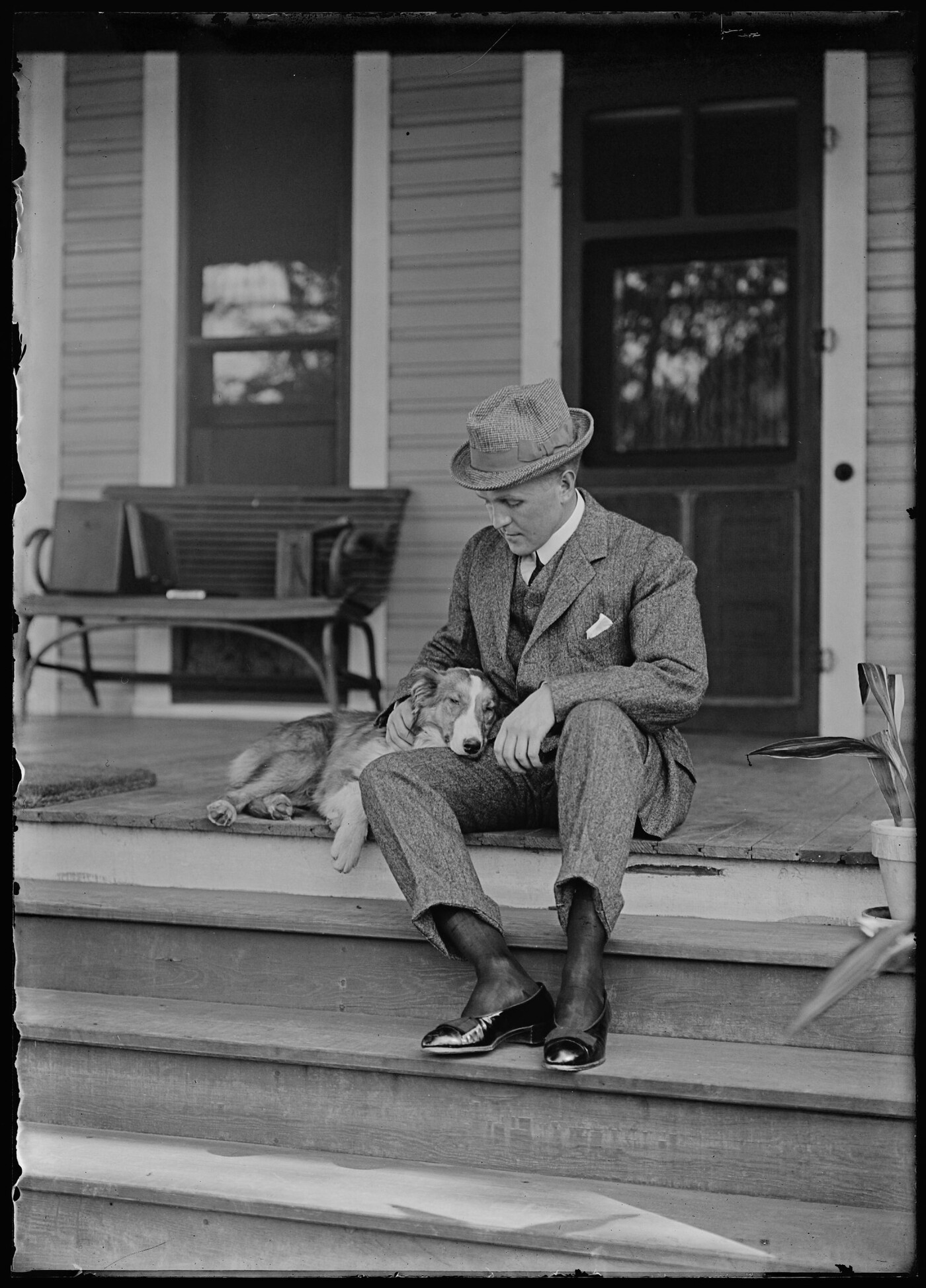 Pattullo with dog on front porch of White home] Amon Carter