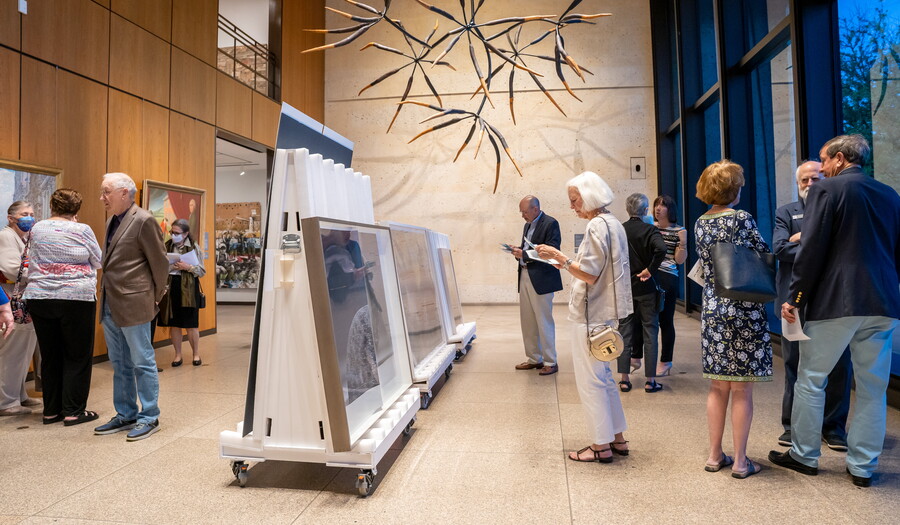 People file past artworks displayed on large easels in the Carter's main gallery.