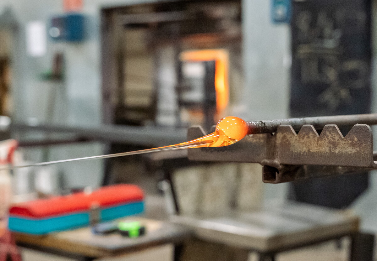 An orange-hot glob of molten glass on the end of a punty.